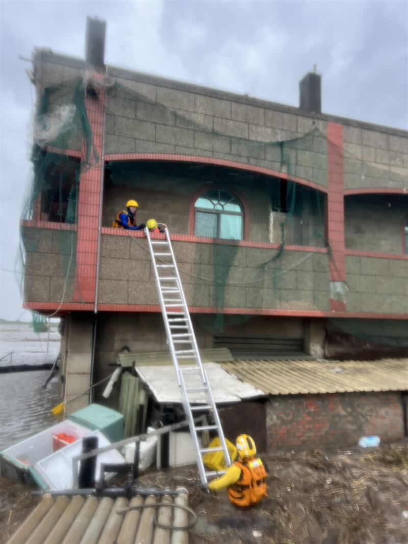 彰化縣大城鄉鄰近出海口的台西村25日上午有養殖池水溢出，造成透天厝1樓淹水近半層樓，4名住戶逃到2樓求救，消防人員出動救生艇、架長梯，協助4人脫困。（民眾提供）中央社記者鄭維真傳真 113年7月25日