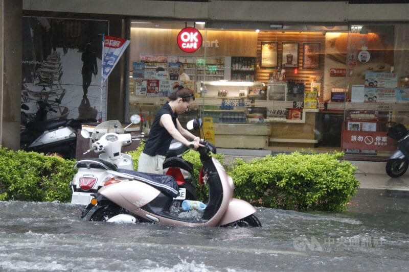 颱風凱米過境帶給高雄強風豪雨，市區有多處道路積淹水，一名民眾25日在前金區牽著機車涉水而過。中央社記者董俊志攝 113年7月25日