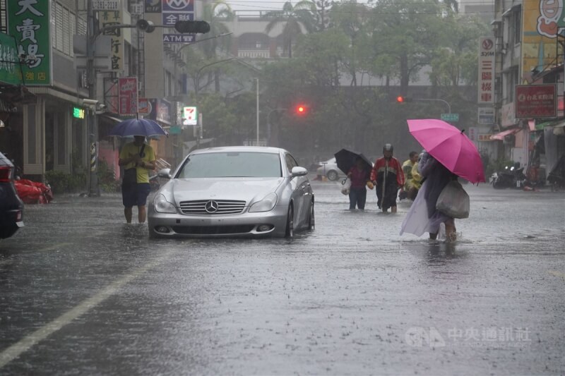 颱風凱米為中南部帶來大量雨水，25日高雄市三民區三鳳宮一帶淹水，有車子拋錨在水中，民眾涉水而過。中央社記者董俊志攝 113年7月25日