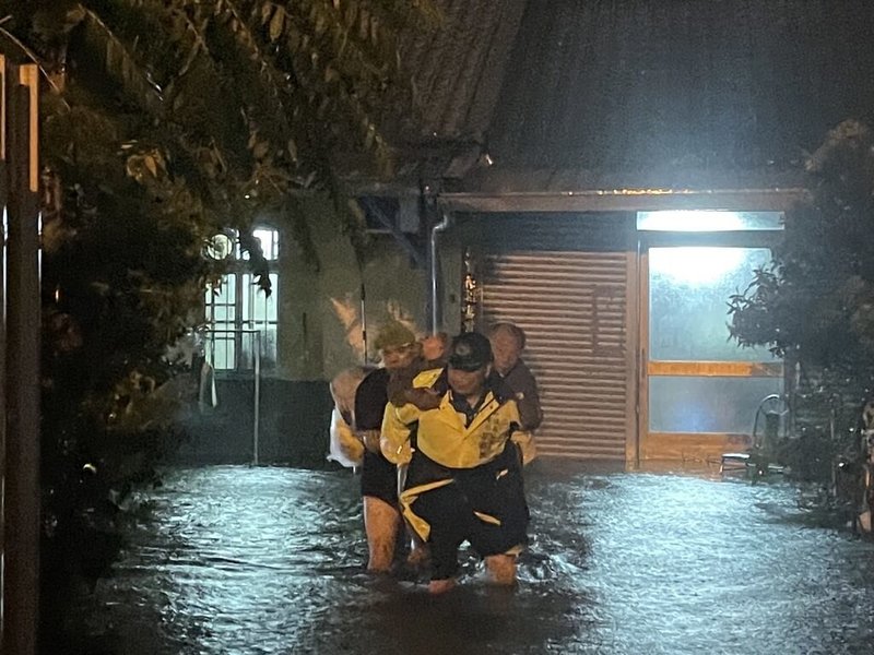 颱風凱米離境，但外圍環流仍影響，台中地區25日深夜持續降雨，清水區民族路有民宅淹水，當地南社里里長崔惠國與民眾背出2名行動不便長者脫困。（民眾提供）中央社記者蘇木春傳真 113年7月26日