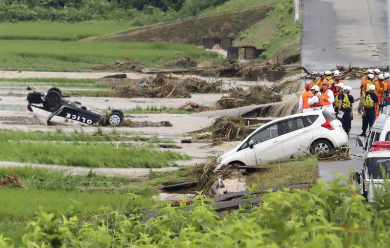 日本東北降下大雨，山形縣新庄市26日可見一輛警車翻覆，車體約一半泡在水中。（共同社）