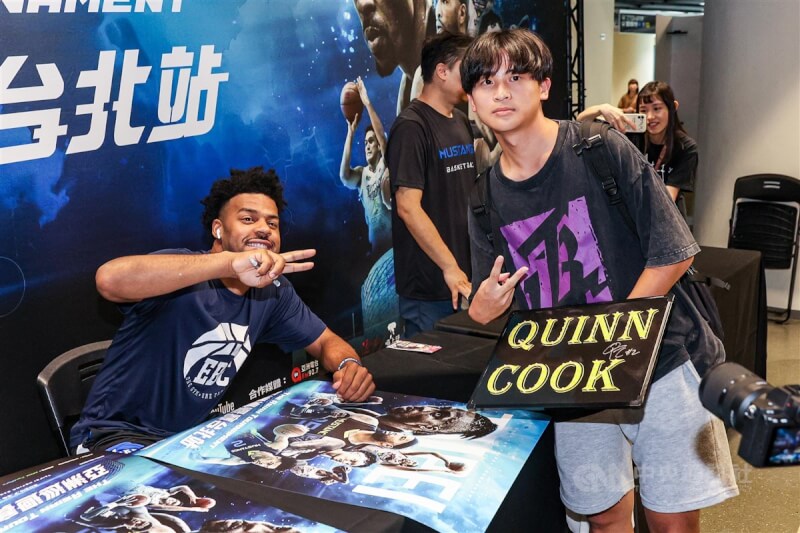 亞洲巡迴賽（TAT）台北站27日在和平籃球館開打，前NBA球星庫克（Quinn Cook）（左）在賽前為球迷簽名，有球迷準備了庫克的姓名看板，庫克也開心合影。中央社記者鄭清元攝 113年7月27日