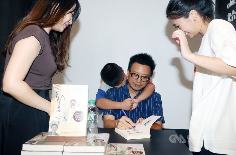 普立茲自傳文學獎得主、「保持真誠」台裔美籍作家徐華(前中)28日在新北市舉辦新書分享會,簽書中途,陪伴他返台的兒子(中後)一度跑來撒嬌,成為可愛插曲。中央社記者郭日曉攝 113年7月28日