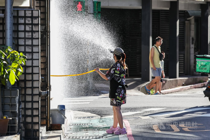 圖為台北市內湖區店家灑水降溫。（中央社檔案照片）