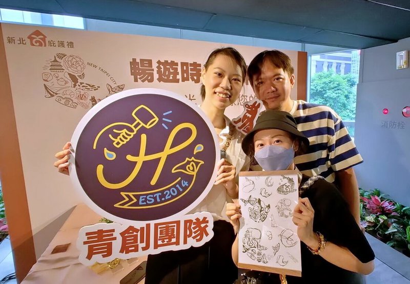 新北市勞工局30日在市府發表第11屆新北庇護禮,手作燙金的皮革活頁手帳本,原始圖騰設計黃凌玲(前)、青創團隊「魟骰篩皮革工作室」設計師何姿諾(後左)、皮革氣動工具專家廖文龍(後右)合影。(新北市勞工局提供)中央社記者黃旭昇新北傳真 113年7月30日