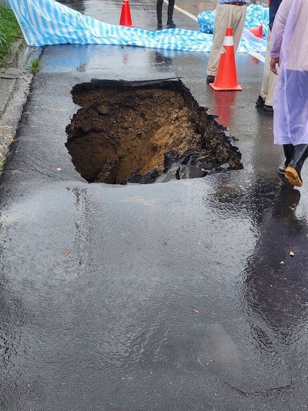 苗栗縣後龍鎮1處興建中建築工地旁的外側路面，出現路基掏空、路面塌陷坑洞，疑與建案開挖地下室有關，苗栗縣政府已要求建商立即停工並提報改善計畫。（苗栗縣政府提供）中央社記者管瑞平傳真  113年7月30日