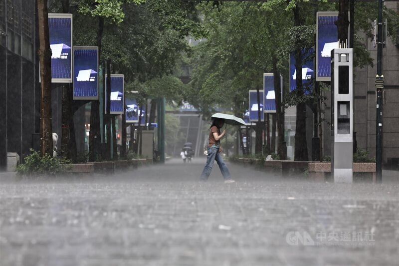 圖為台北市信義區大雨，民眾撐傘。（中央社檔案照片）