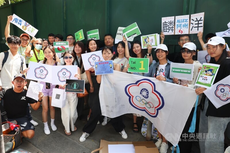 2024巴黎奧運羽球男雙金牌戰將在當地時間4日下午開打,台灣組合李洋、王齊麟力拚摘金,台灣留學生Rita(前右4)自發性做了許多不違規的「諧音」哏加油看板分發送給球迷,邀台灣加油團一起為「麟洋配」加油。中央社 113年8月4日
