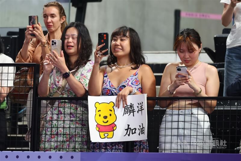 有球迷自備創意標語到場為麟洋配加油,並以手機捕捉賽事精彩時刻。中央社 113年8月5日