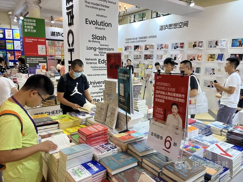 第20屆上海書展14日在上海展覽中心揭幕,讀者在出版社展位閱讀、選書。中央社記者李雅雯上海攝 113年8月14日