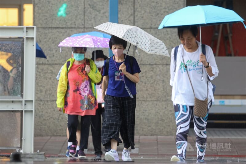 圖為台北市大安區出現短暫陣雨，民眾撐傘過馬路。（中央社檔案照片）