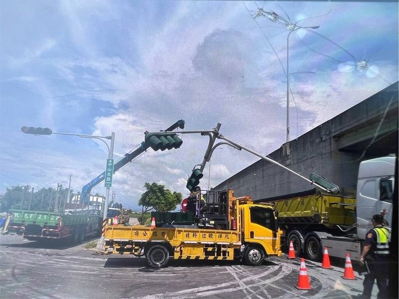 一輛曳引車16日中午行經台中市大安區五甲北路與西濱公路平面路口時，因後車斗電動棚架故障自動升起，勾到中央分隔島上的號誌桿，導致號誌桿彎曲，電線垂吊在車道上，一度影響交通。（警方提供）中央社記者趙麗妍傳真  113年8月16日