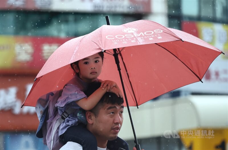 圖為台北市萬華區午後出現短暫陣雨，民眾走在路上撐起雨傘。（中央社檔案照片）