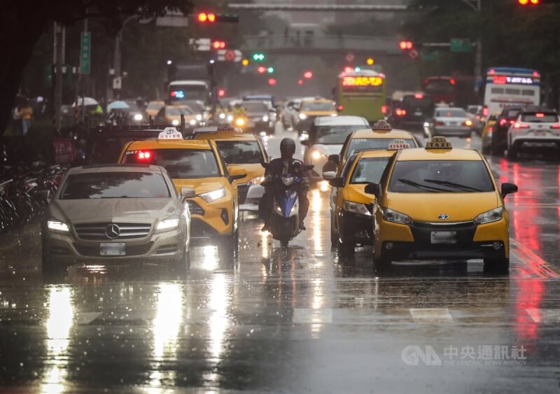 圖為15日下午北市信義區雨勢漸大，許多用路人打開車燈保持安全。中央社記者裴禛攝 113年8月15日