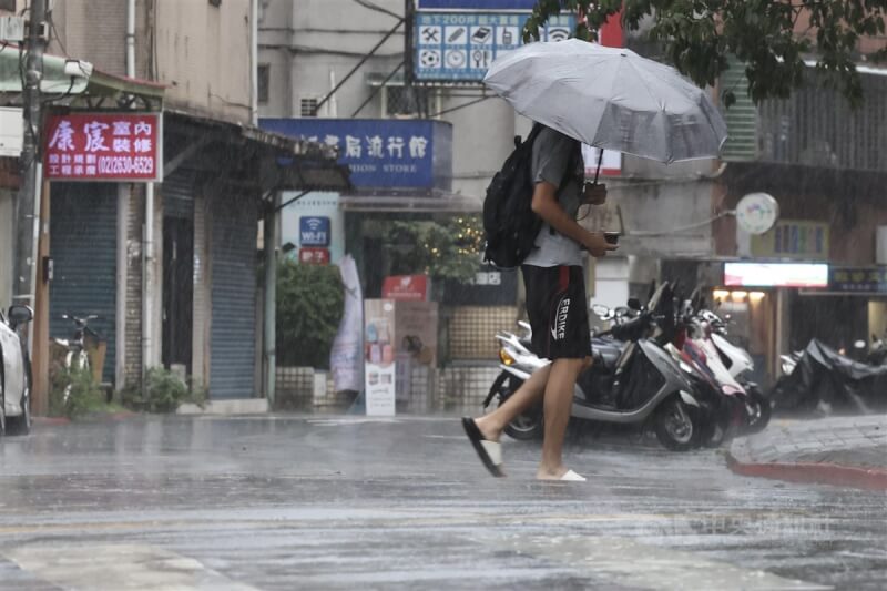 台北市內湖區下雨，民眾穿拖鞋撐傘過馬路。中央社記者翁睿坤攝 113年8月20日