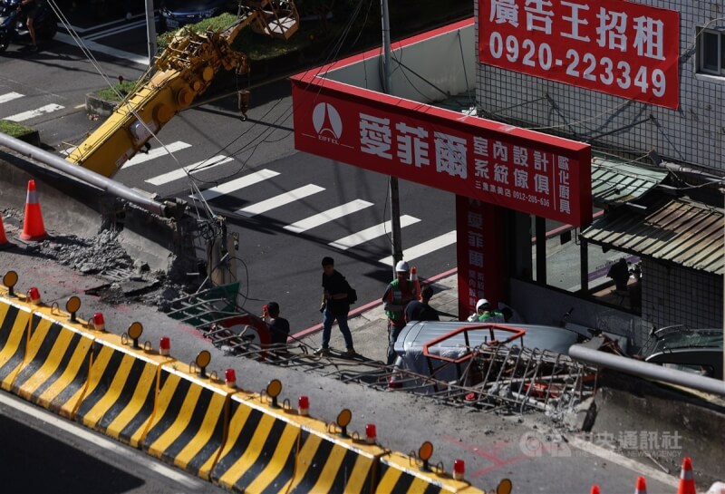 新北市三重區台1線中山高架道路往忠孝橋方向20日清晨發生聯結車載送鋼梁翻覆事故,造成高架道路圍籬及道路遭砸毀,並波及橋下停放車輛,目前事故路段已開放單線通行。圖為21日上午受損部分持續進行修復。中央社記者趙世勳攝 113年8月21日