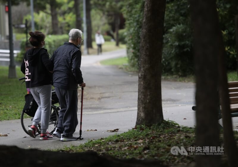 圖為外籍幫傭與雇主在公園內散步。（示意圖／中央社檔案照片）
