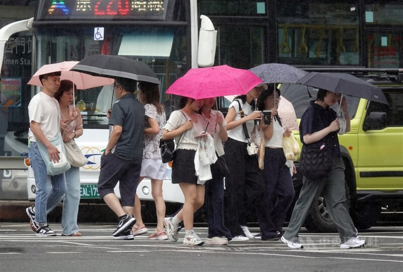 圖為台北西門町民眾撐傘過馬路。（中央社檔案照片）