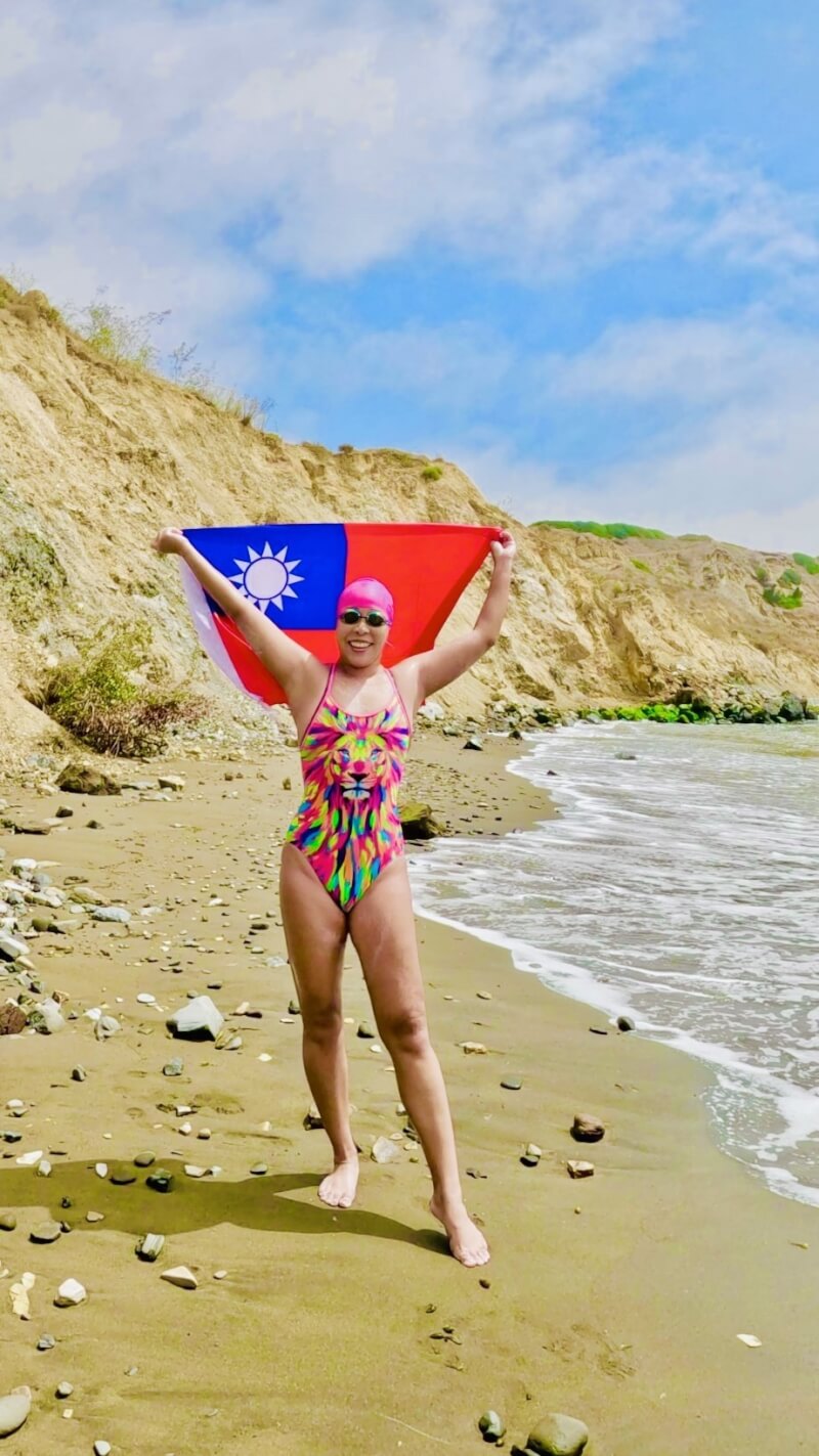 台灣長泳女將許汶而27日以13小時21分鐘泳渡加州的卡塔利那海峽,踏上加州海灘之後,拿出中華民國國旗拍照。(許汶而提供)中央社記者林宏翰洛杉磯傳真 113年8月30日