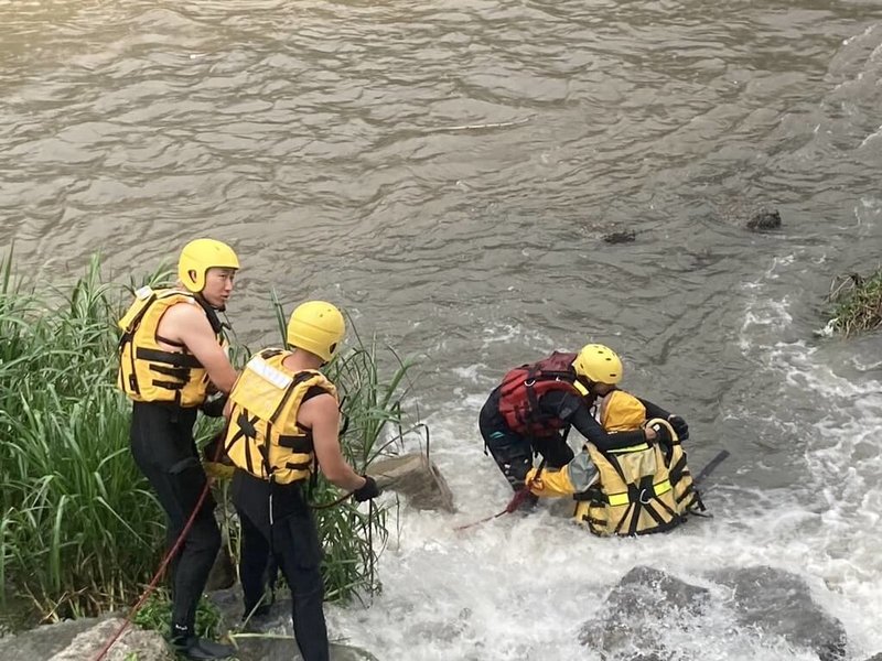 台中市1日下午下起大雨致溪水暴漲，豐原區南陽橋旁發生釣客受困沙洲意外，消防局出動人員架設雙節梯，為釣客穿著救生衣及繩索後，攙扶保護至岸上。（民眾提供）中央社記者郝雪卿傳真  113年9月1日