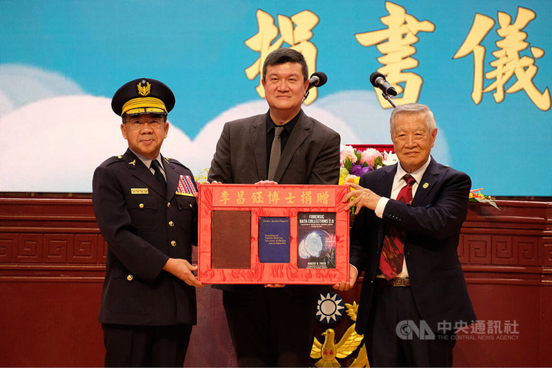中央警察大學1日舉辦88週年校慶暨開學典禮,刑事鑑識專家李昌鈺(右)出席,並捐贈珍貴典籍資料,由校長楊源明(左)代表接受,內政部次長馬士元(中)見證。中央社記者吳睿騏桃園攝 113年9月1日