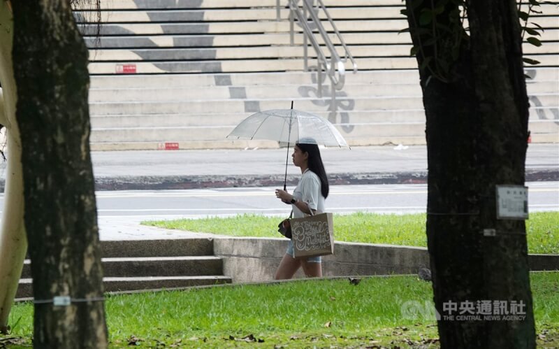 圖為南港民眾雨中撐傘。（中央社檔案照片）