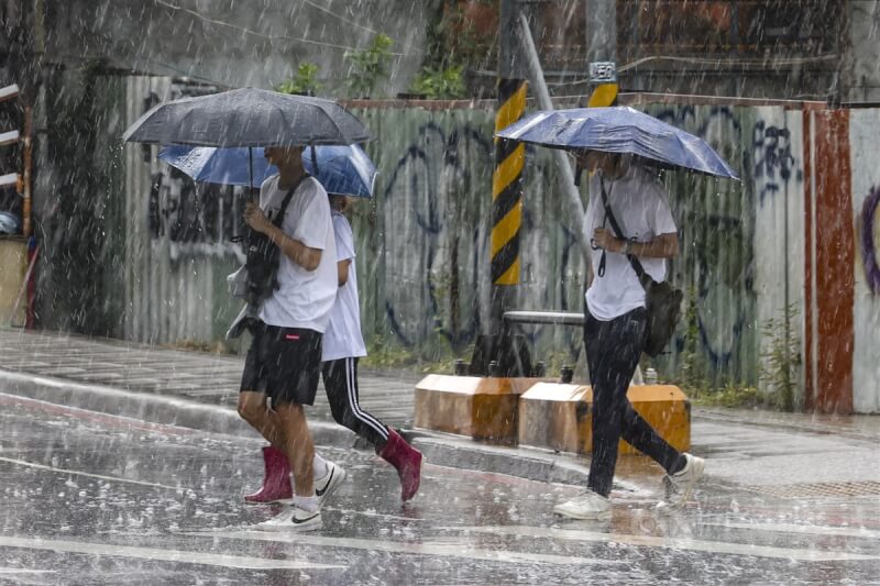 圖為7日新北市新店區午後突降陣雨，許多民眾撐傘通勤。中央社記者鄭清元攝 113年9月7日