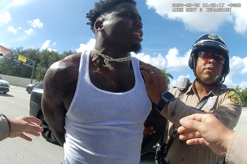 NFL非裔球星希爾（中）8日因交通違規遭警察攔下受到壓制上銬。（Miami-Dade Police Department/Handout via 路透社）