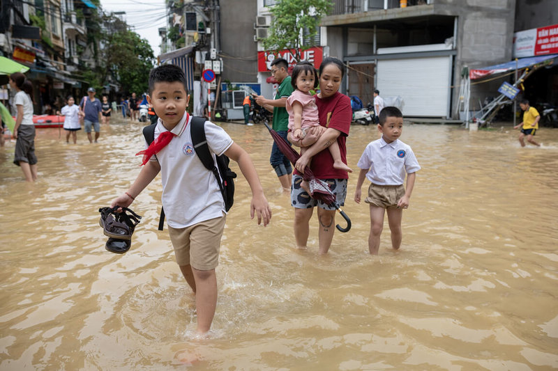 越南首都河內市受到颱風摩羯影響多地淹水，圖為河內市的小學生下課後在母親的陪伴下涉水走回家。（聯合國兒童基金會越南辦事處提供）中央社記者陳家倫河內傳真  113年9月12日