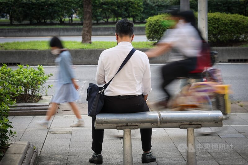 台北市中正區上班族在路邊小憩。（中央社檔案照片）