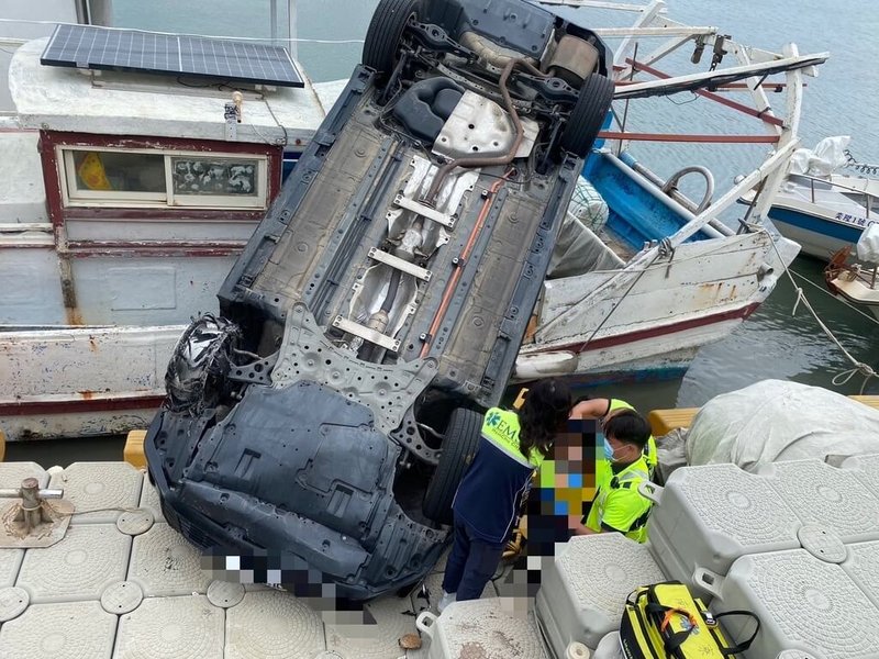 新竹市消防局14日下午接獲通報，指1輛自小客車不明原因在南寮漁港衝入海中，消防人員到場發現該車掉落漁邊浮動碼頭及1艘停靠在旁的漁船上，立刻將受困車內的男性駕駛救出送醫，幸無生命危險。（新竹市消防局提供）中央社記者魯鋼駿傳真  113年9月14日