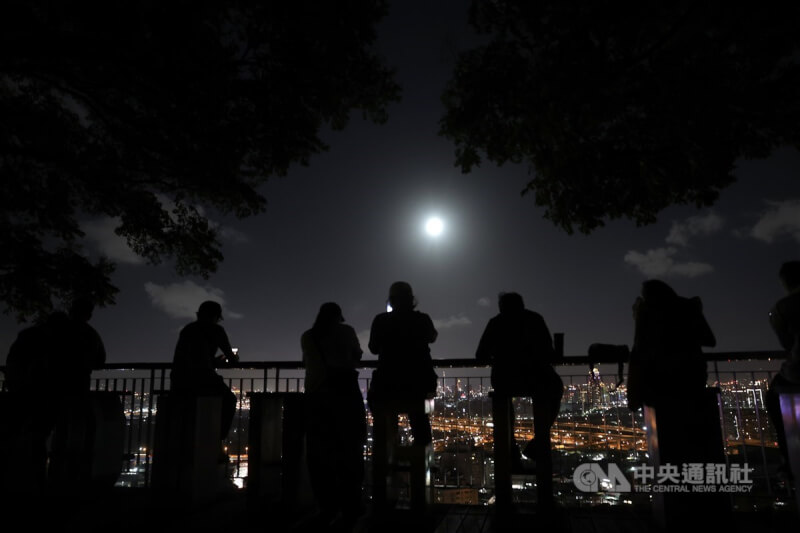 中秋節到來,新北市五股區一處景觀公園17日晚間有不少人聚集等待月亮露臉,待一輪明月高掛天際,現場民眾也紛紛拿出手機捕捉美景。中央社記者趙世勳攝 113年9月17日