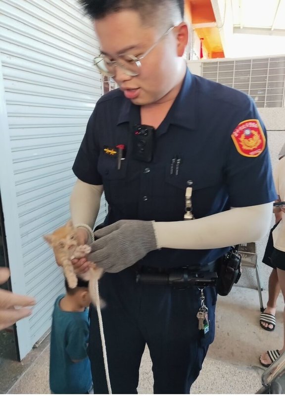 台中市清水區有車主發現引擎室躲了一隻小貓咪,請來警方幫忙救援,員警逗弄小貓咪時,以繩索套在牠身上,順利將貓咪拉出引擎室。(民眾提供)中央社記者趙麗妍傳真 113年9月18日