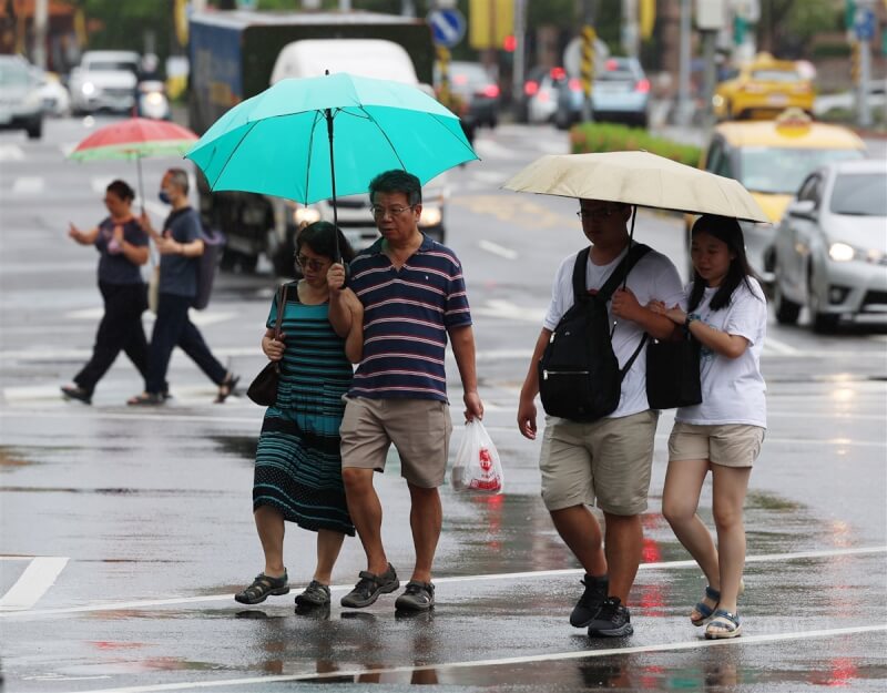 圖為台北市信義區民眾撐傘遮擋雨勢。（中央社檔案照片）