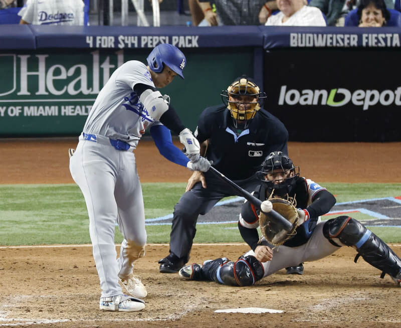 美國職棒大聯盟MLB道奇日籍球星大谷翔平（左），19日在對馬林魚第7局時擊出第50支全壘打，締造MLB史上首度50轟50盜紀錄。（共同社）