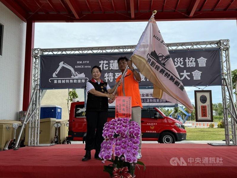 花蓮縣重機械防災協會21日在花蓮縣消防訓練大樓舉行特殊救援隊成立大會,花蓮縣長徐榛蔚(左)授旗給花蓮縣重機械防災協會理事長張銘偉(右)。中央社記者張祈攝 113年9月21日