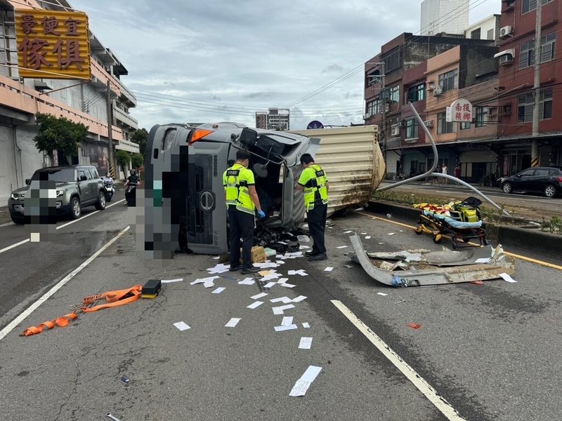 新竹市西濱路1段22日發生貨櫃聯結車翻覆事故，駕駛受困車內、意識模糊，警消到場救出送醫，確切事故發生原因待調查釐清。（新竹市消防局提供）中央社記者魯鋼駿傳真  113年9月22日