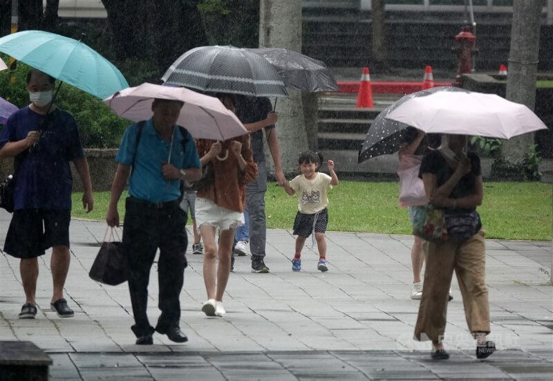 圖為南港地區民眾撐傘出門。（中央社檔案照片）