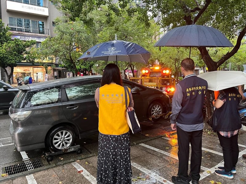 新竹市一名男子的自小客車遲遲未繳牌照稅及罰鍰，日前停放在路邊停車格時，被相關通報機制發現為欠稅車輛，法務部行政執行署新竹分署隨即派員前往執行拖吊查封。（行政執行署新竹分署提供）中央社記者魯鋼駿傳真  113年9月27日