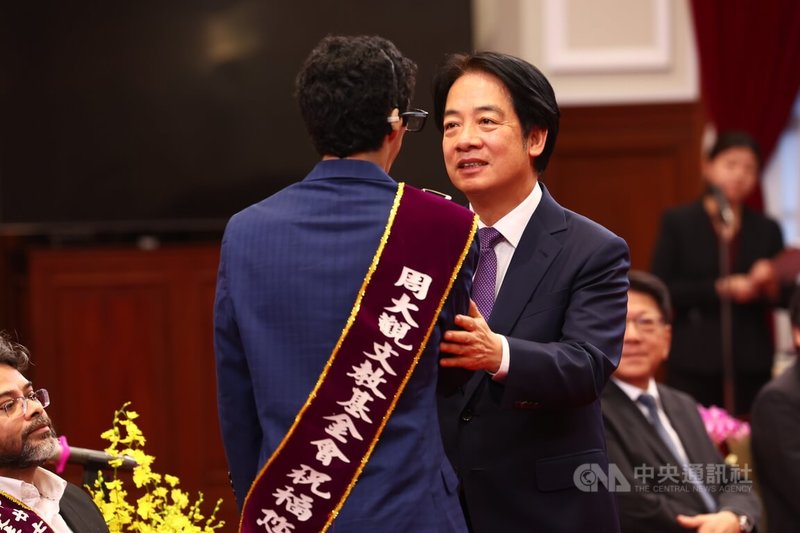 總統賴清德(中右)27日下午接見第27屆全球熱愛生命獎章得主暨家屬,向墨西哥8指鋼琴勇士大衛.岡薩雷斯(David González)(前背對者)握手致意。中央社記者王騰毅攝 113年9月27日