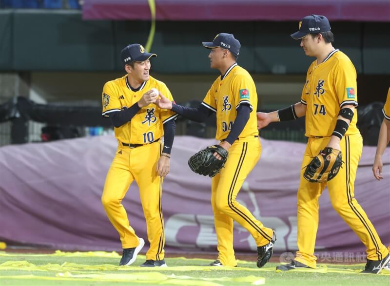 中華職棒中信兄弟29日作客樂天桃園棒球場，最終以8比5擊退樂天桃猿，自力下半季封王，救援投手吳俊偉（中）賽後將比賽勝利球交給總教練平野惠一（左）。中央社記者張新偉攝 113年9月29日