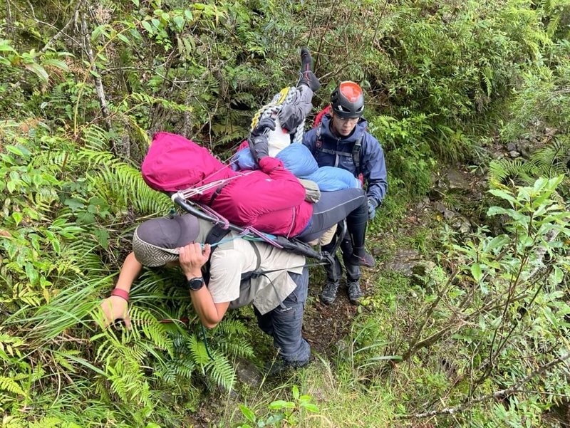 16人登山隊28日從南投縣信義鄉雙龍林道入山，黃姓女子29日下山途中摔落邊坡，左大腿疑骨折。搜救人員29日入山，趕在颱風山陀兒來襲前救出黃女，救援人員以背負方式下撤。（南投縣消防局提供）中央社記者蕭博陽南投縣傳真  113年9月30日