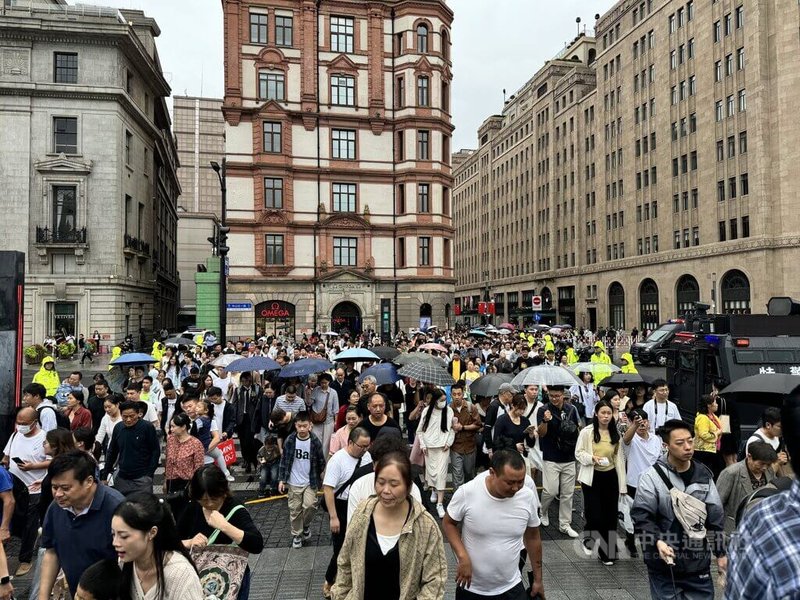 中國十一連假首日，上海雖然下著小雨，但民眾出遊興致不減，許多景區、商圈都出現大量人潮。圖為準備前往外灘觀景台的民眾。中央社記者吳柏緯上海攝  113年10月1日