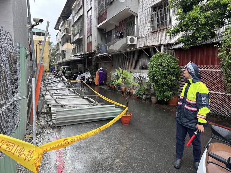 颱風山陀兒來襲，高雄2日凌晨起風雨加劇，三民區一處工地圍籬傾倒壓到一旁停放的機車；員警獲報到場處置，拉起封鎖線並通報施工等相關單位前來排除。（高市三民一警分局提供）中央社記者洪學廣傳真  113年10月2日