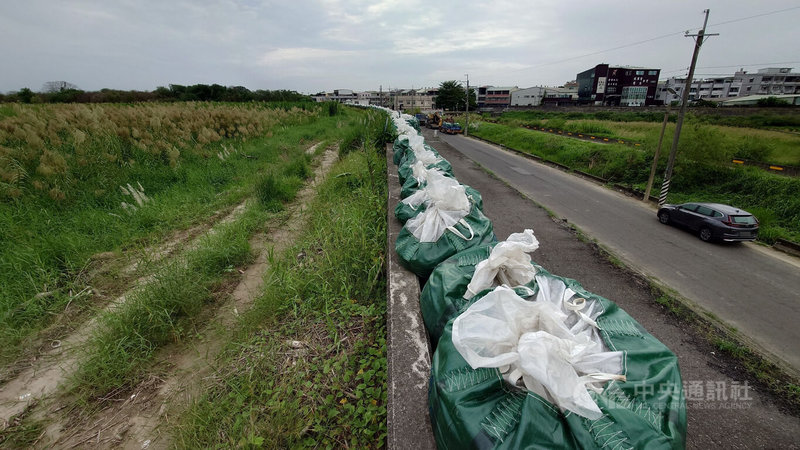 颱風山陀兒逼近,水利署第五河川分署已在靠近嘉義縣美上美社區抽水站的八掌溪內溪州段堤防上,堆置大量沙包,以備不時之需。中央社記者蔡智明攝 113年10月2日