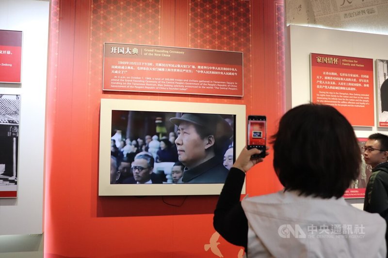 今年是中共建政75年，官方推動「紅色旅遊」。圖為今年中國十一假期期間，北京的香山公園內的一個展覽，播放75年前的「開國大典」，一位遊客拿著手機錄影。中央社記者呂佳蓉北京攝  113年10月3日