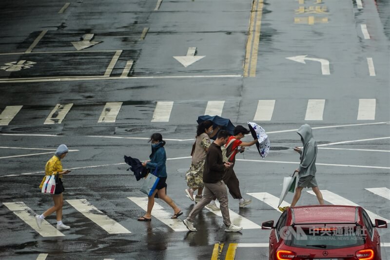 颱風山陀兒3日中午已登陸高雄，台北市區午後亦有陣風及陣雨，台北市信義區街頭民眾過馬路時紛紛低著頭、緊握雨傘抵禦強陣風。中央社記者裴禛攝 113年10月3日