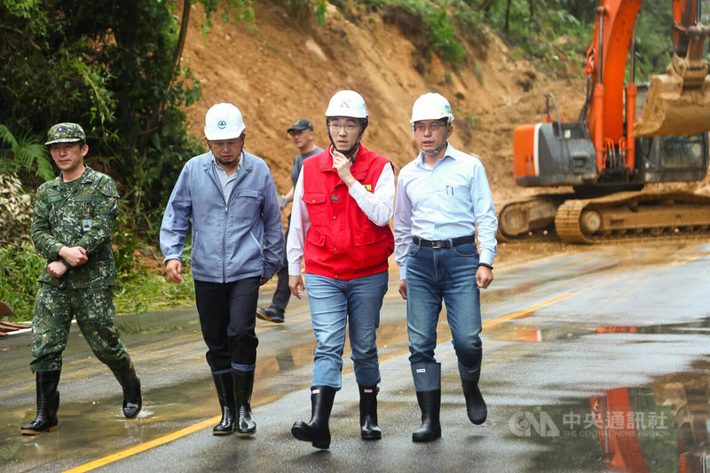 基隆市4日凌晨大雨,新豐街海中天社區前山坡大面積土石崩落走山,造成交通中斷,市府動員機器與人力搶修,市長謝國樑(右2)傍晚到場了解道路搶通進度。中央社記者王騰毅攝 113年10月4日
