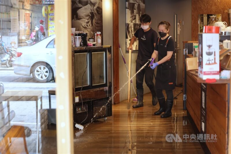 新北市金山區日前遭豪雨重創，淹水災情嚴重，雖然水已退去，許多店家6日仍持續清理環境。圖為金山街區一家咖啡店員工清洗地板淤泥。中央社記者王飛華攝 113年10月6日