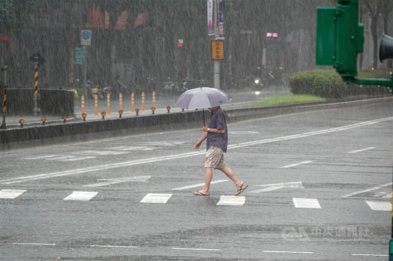 台北市南港區民眾撐傘穿拖鞋出門。（中央社檔案照片）